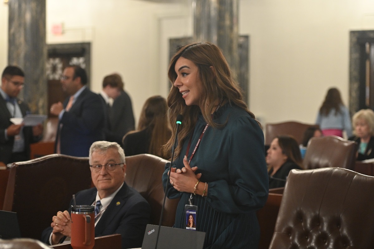 Senator Toro smiles while speaking into a microphone in the Senate chambers.